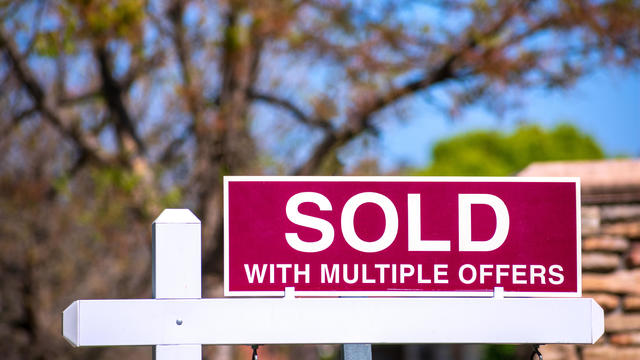 SOLD With Multiple Offers real estate sign near purchased house. 