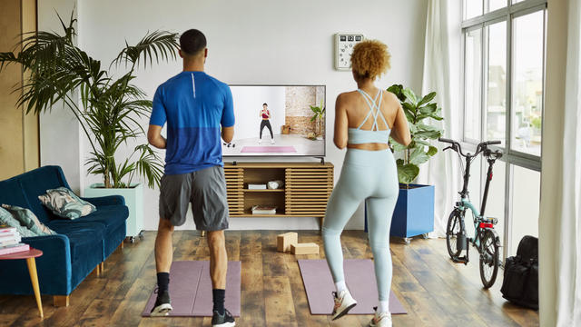 Couple Watching Online Exercise Class At Home 