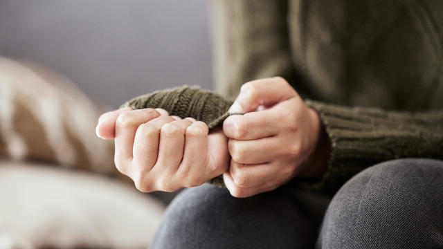 Sad woman sitting on couch alone at home 